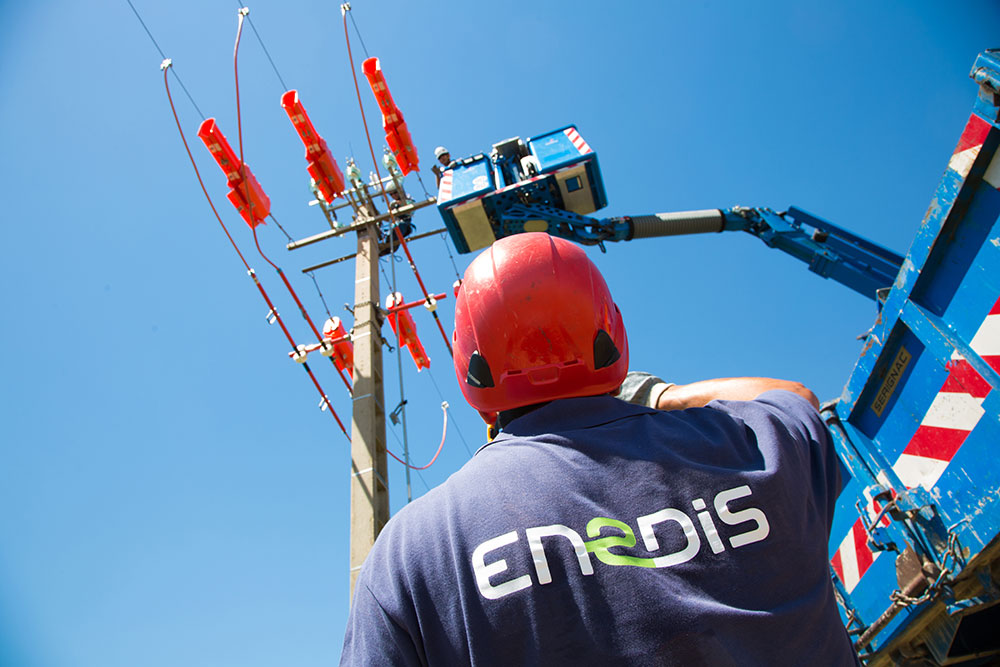 Un technicien d’enedis travaillant en hauteur sur une ligne électrique